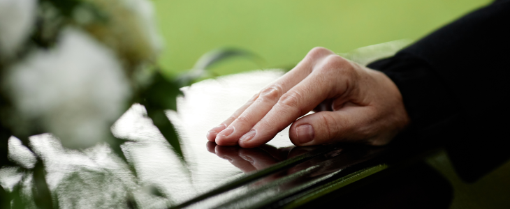 Woman with her hand on top of a casket to represent wrongful death