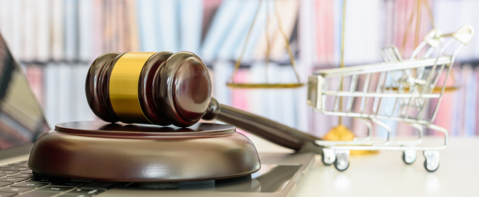 Gavel and mallet next to a shopping cart to represent product liability